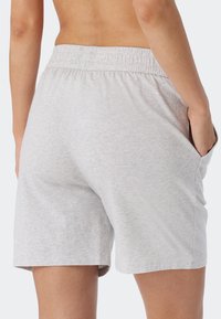 Lichtgrijze katoenen shorts met een elastische tailleband, zijzakken en een relaxte pasvorm. Glad textuur en eenvoudig ontwerp zonder patronen.
