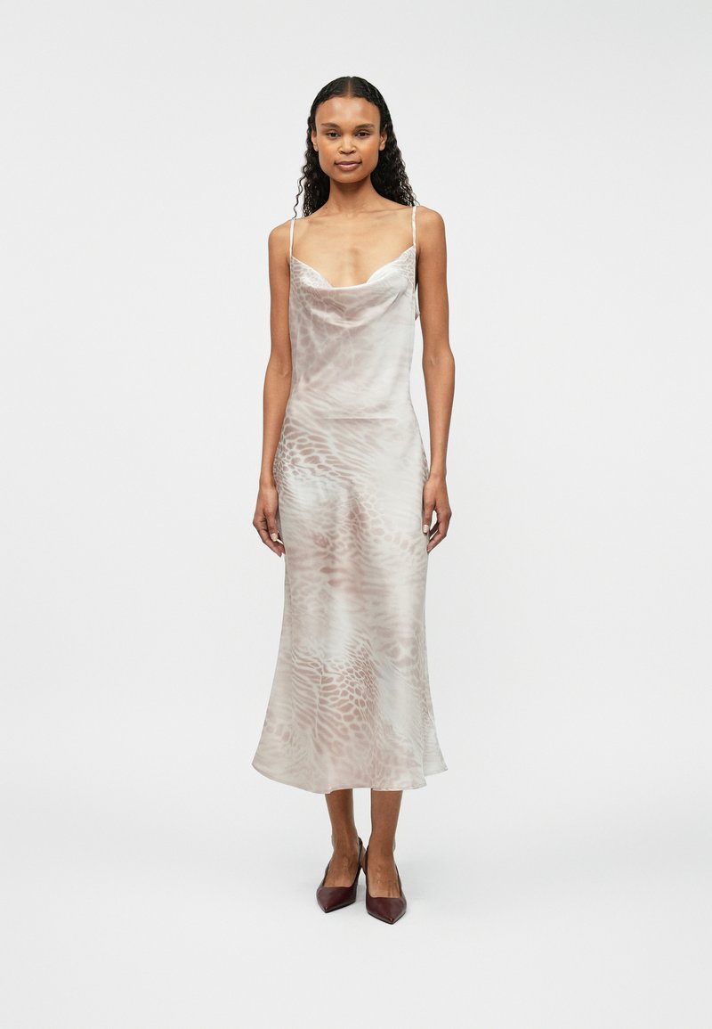 Φόρεμα slip με λαιμό cowl σε ανοιχτό μπεζ χρώμα με διακριτό μοτίβο ζωντανών. Διαθέτει λεπτές τιράντες και ρέον ύφασμα που πέφτει κομψά.