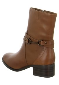 Bruine leren enkellaars met een ronde neus, een zijgesp met details, getextureerde accenten en een gestapeld hak. Gladde afwerking, minimalistische stiksels.