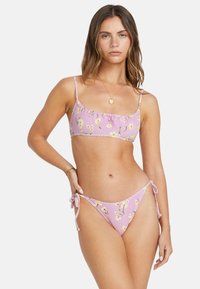 Pink bikini set featuring a striped design and floral pattern. Top has narrow straps and frilled edges; bottom ties at the sides.