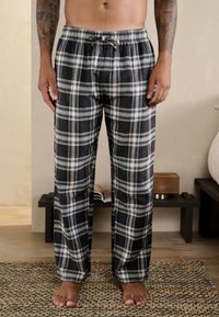 Sort-hvide ternede pyjamasbukser med elastisk linning og snøre, med løs pasform og blødt stof.