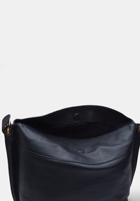 Black leather shoulder bag with a soft texture, open top, and gold hardware accents, featuring a subtle inner pocket detail.