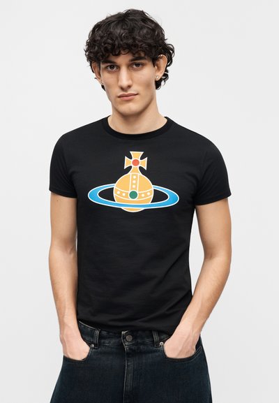 Camiseta negra de manga corta con un gráfico colorido de un planeta estilizado y anillos en naranja, azul y verde. Material suave y ajustado.
