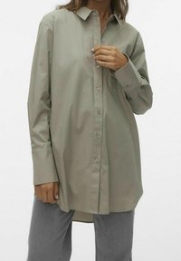Lichtgroen button-down shirt met een kraag, lange mouwen en een relaxte pasvorm. Beschikt over een zak aan de linkerkant en heeft een gladde, zachte stof.