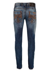 Jean en denim bleu foncé avec un délavage, présentant des poches arrière brodées et une étiquette en cuir sur la taille.
