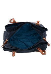 Borsa blu navy con manici in pelle beige, chiusura con zip e interni caratterizzati da un rivestimento blu brillante e numerosi scomparti.
