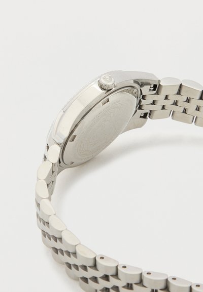 Hõbedane roostevabast terasest kell, millel on ühendatud käevõru, ümmargune korpus, tekstuuriga kroon ja sile, graveeritud kella sihverplaat.