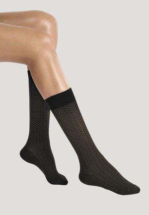Svarta knähöga strumpor med ett strukturerat mönster och kontrasterande ribbad överkant. Tillverkade av ett mjukt material med en slät yta.