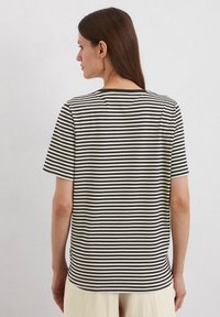 Gestreiftes T-Shirt mit horizontalen schwarzen und weißen Streifen, weichem Stoff, kurzen Ärmeln, lässiger Passform und Rundhalsausschnitt.