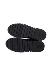 Schwarz-rubberisierte Schuhsohlen mit einer gerippten Textur, die ein herzförmiges Ausschnittmuster und das Wort "CRICK.IT" reliefartig auf der Oberfläche eingeprägt haben.