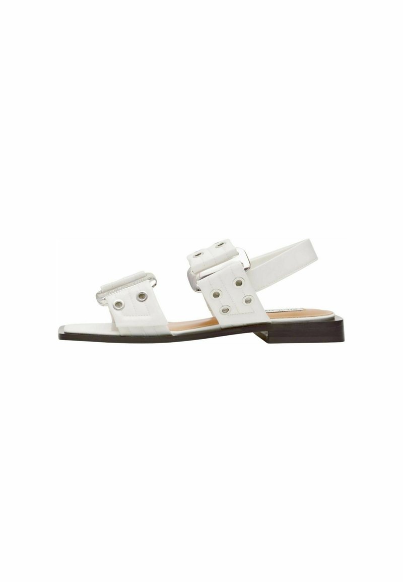 Sandalias blancas con dos correas anchas que presentan recortes circulares, una correa trasera y un bajo tacón cuadrado marrón. Textura suave y diseño minimalista.