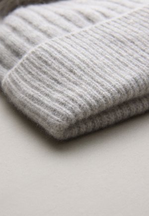 Vaaleanharmaa neulepaita, joka on taiteltu. Siinä on ribbineulos, pehmeä villamateriaali ja siisti, yksinkertainen muotoilu ilman näkyviä koristeita.