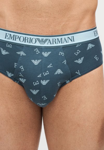 Σκούρα μπλε αντρικά εσώρουχα Emporio Armani με ανοιχτό μπλε μέση και επαναλαμβανόμενο μοτίβο λευκών λογότυπων και γραμμάτων της μάρκας.