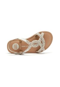 Sandaía blanca con una correa brillante adornada con pequeños embellishments, suela plana y plantilla color canela con el logotipo de la marca.