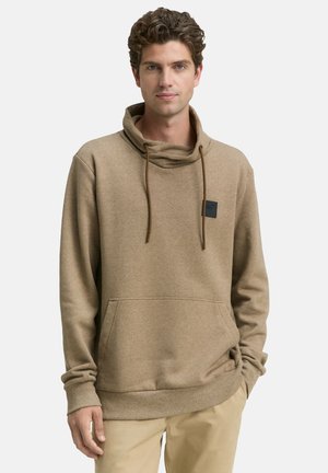 Bruine hoodie gemaakt van een zachte stof, met een hoge kraag, trekkoorden en een patch op de borst. Kangoeroezak en geribbelde manchetten.