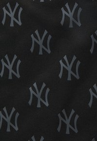 Tissu noir avec un motif gris répétitif du logo des New York Yankees, texturé avec un léger éclat.