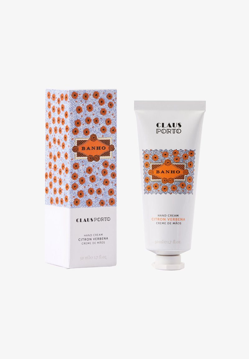 Crème pour les mains Claus Porto, tube blanc orné de motifs de roses orange, accompagné d'une boîte décorative au design similaire, portant l'inscription "BANHO".