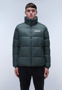 Giubbotto imbottito di colore verde scuro con colletto alto, design trapuntato, zip frontale e dettaglio con logo sul petto. Dotato di polsini elasticizzati.