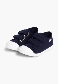 Tumesinised kangast kingad valgete kummist tallade ja varvaskatetega, millel on kaks Velcro rihma ja kareda pinnaga ülemine osa haardumise jaoks.