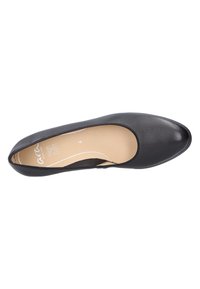 Black leather ballet flat with a rounded toe, elasticized trim, and beige insole; smooth texture and minimalistic design.