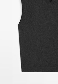 Maglione smanicato in maglia grigio scuro con scollatura a V, posato in piano su uno sfondo bianco, che mostra il lato sinistro e l'orlo inferiore.