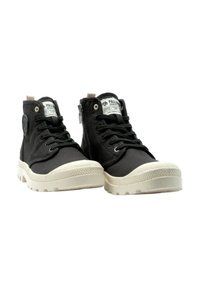 Zapatillas altas de lona negra con suelas de goma blanca, con un logotipo redondo, cordones y una cremallera lateral. Duraderas y diseñadas para la comodidad.