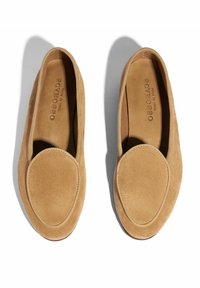 Beige Wildlederschlupfschuhe mit abgerundetem vorderen Teil, glatterTextur und einem gesteppten Akzent um die Öffnung. Flache Sohlenkonstruktion.