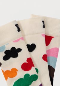 Τρία κάλτσες σε κρεμ χρώμα με πολύχρωμα αφηρημένα μοτίβα νεφών και καρδιών σε μαύρο, κόκκινο, πράσινο, πορτοκαλί, ροζ, μπλε και καφέ.