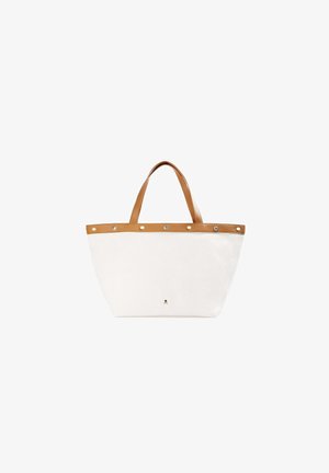 Canvas tas met een witte lichaamskleur en tan leren handvatten. Kenmerkt zich door een decoratieve tan leren band met zilveren studs aan de bovenkant.