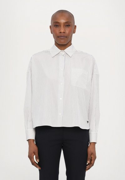 Chemise blanche rayée à boutons avec col, coupe ample et poche poitrine unique. Tissu doux avec manches longues et poignets contrastés.
