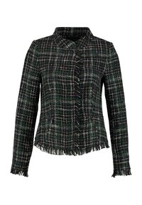 Giacca a quadri verde scuro e nera con bordi frangiati, maniche lunghe, tasche frontali con zip e colletto alto.