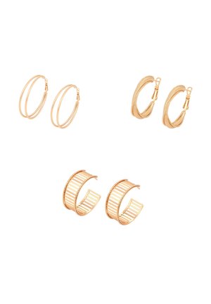 Drie paar gouden oorbellen met verschillende texturen en ontwerpen, gerangschikt op een witte achtergrond.