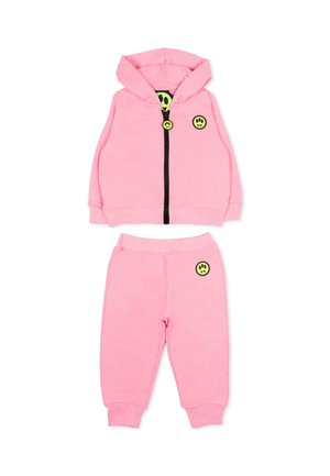 Różowy zestaw dla malucha, składający się z bluzy z kapturem i spodni dresowych, z żółtymi naszywkami w kształcie uśmiechniętych buziek oraz czarnym zamkiem błyskawicznym na bluzie.