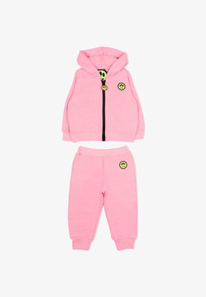 Roze hoodie- en joggingbroekset voor peuters met gele smiley-patches en een zwarte ritssluiting aan het jack.