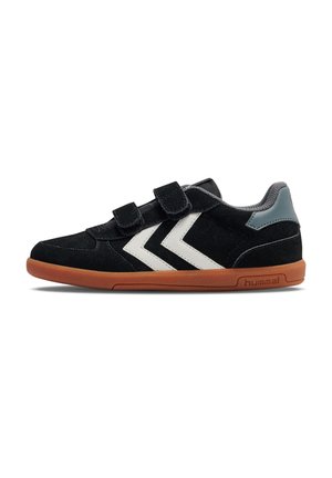 Schwarze Wildlederschuhe mit weißen Chevronstreifen, grauen Akzenten und zwei verstellbaren Klettverschlussriemen; braune Gummisohle.