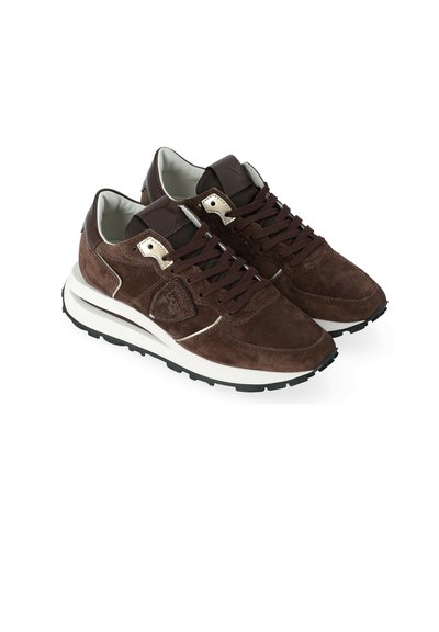 Sneaker in suede marrone con una suola intermedia bianca, suola in gomma nera e dettagli metallici. Presentano chiusura con lacci e colletto imbottito.