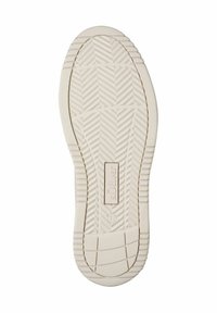 Sole of a shoe with a textured pattern, primarily in off-white. Features a central logo and a rounded heel.