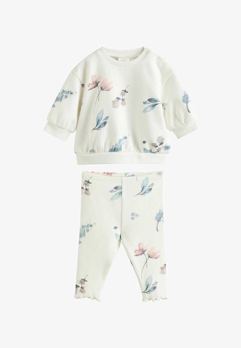 Béžový detský outfit s dlhými rukávmi a nohavicami, zdobený jemnými ružovými, modrými a zelenými kvetinovými vzormi.