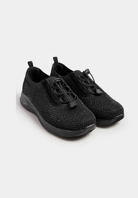 Svarta sportskor med en texturerad ovandel täckt av små strassstenar. Har ett elastiskt snörningssystem och en vadderad ankelkrage.