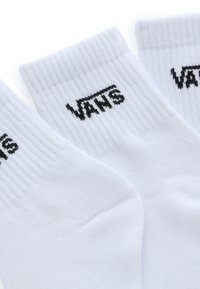 Hvide bomuldsokker med ribbede manchetter, der har et sort broderet "VANS" logo på siden. Blød tekstur, standard atletisk design.