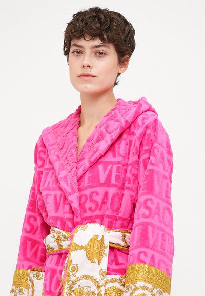 Rosa Bademantel aus plüschigem Stoff mit strukturierter Musterung. Verfügt über einen kontrastierenden weißen und goldenen Gürtel mit aufwendigen Designs und Taschen.