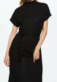 Schwarzes geripptes Kleid mit hohem Ausschnitt, kurzen Ärmeln und gebundenem Taillenbund. Der Stoff hat eine subtile Textur und eine taillierte Silhouette.