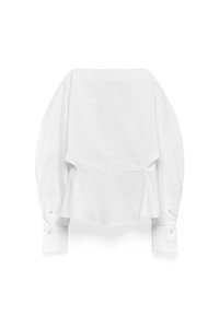 Witte katoenen blouse met een peplumontwerp, lange mouwen, knoopmanchetten en een gebogen zoom. Soepele textuur met minimale stikdetails.