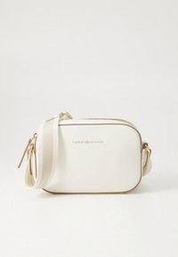 Biela vegánska kožená crossbody taška so zlatým kovaním, vybavená zipsovým zatváraním, nastaviteľným popruhom a vyrazeným logom na prednej strane.