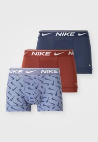 Three pairs of men's boxer briefs: blue with a patterned design, solid navy, and rust red. Each features a branded waistband with "Nike" logo.