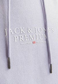 Lila kapucnis hoody, puha textúrával, fehér "JACK & JONES PREMIUM" logóval és ezüstszínű fém végződésekkel a zsinórokon.