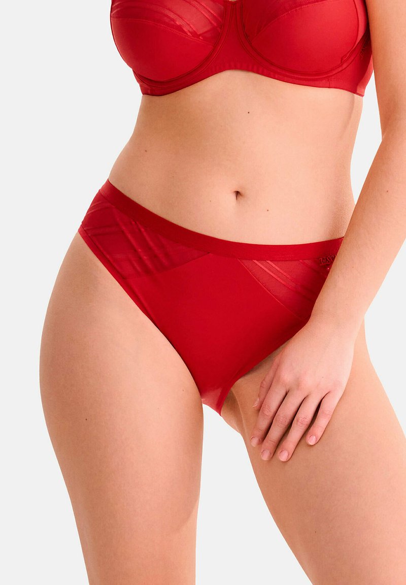 Culotte rouge avec un waistband lisse et élastique, accents en panneaux transparents et détails de texture géométrique sur les côtés. Conçues pour le confort et un ajustement parfait.