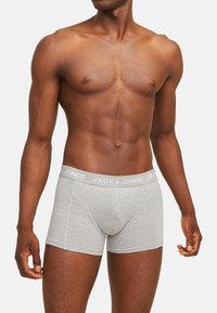 Grijze boxershorts met een witte elastische tailleband gemarkeerd "JACK & JONES," met een aansluitend ontwerp en zachte katoenmaterialen.