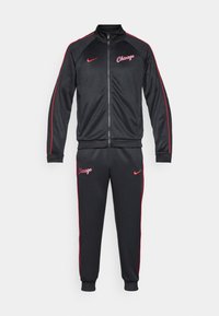 Trening athletic de culoare neagră, cu accente roșii; jachetă cu fermoar ce include logo-ul "Chicago" și pantaloni asortați cu manșete elastice și logo-ul Nike.