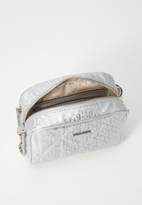 Geantă de mână argintie cu un exterior texturat, având un model distinct. Dispune de un închizător tip fermoar, interior bej cu logo și o curea din lanț.